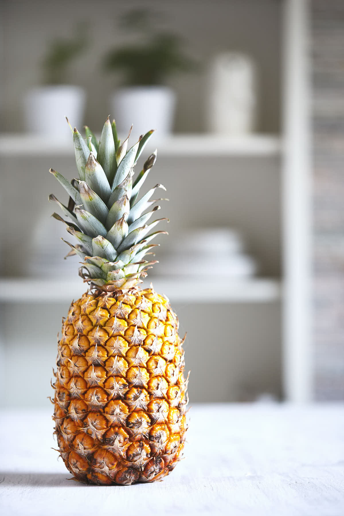 Side view of pineapple on a wooden table