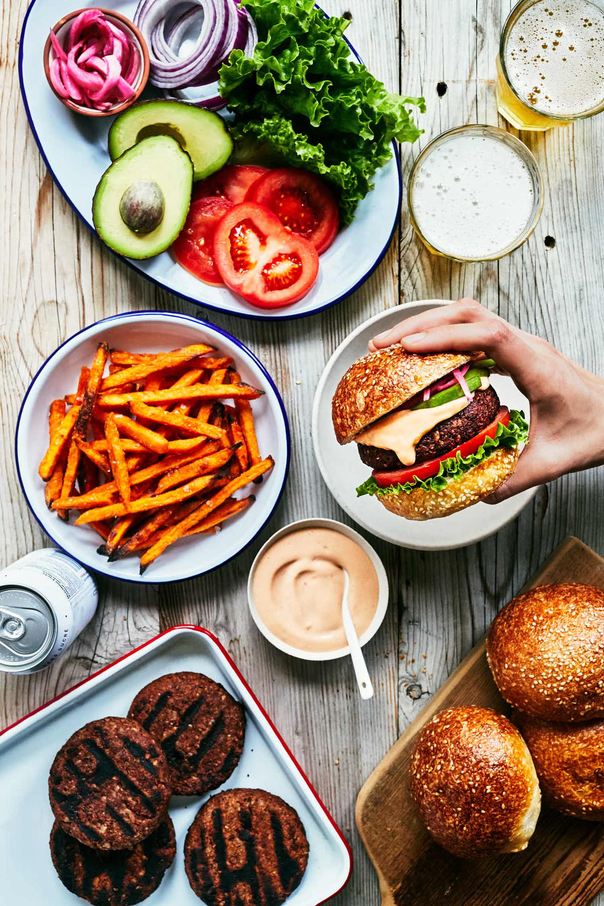 Table scene with chipotle black bean burgers, sweet potato fries and chipotle mayo