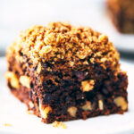 Close up side view of chocolate walnut banana coffee cake with another serving in the background