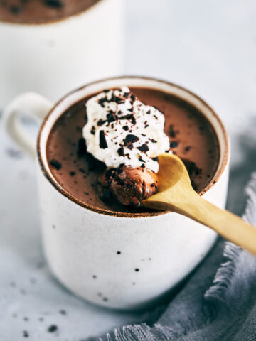 Chocolate chai pot de creme in a cup with a spoon scooping out a bite
