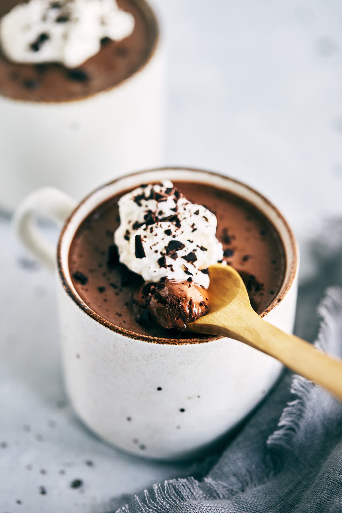 Chocolate chai pot de creme in a cup with a spoon scooping out a bite