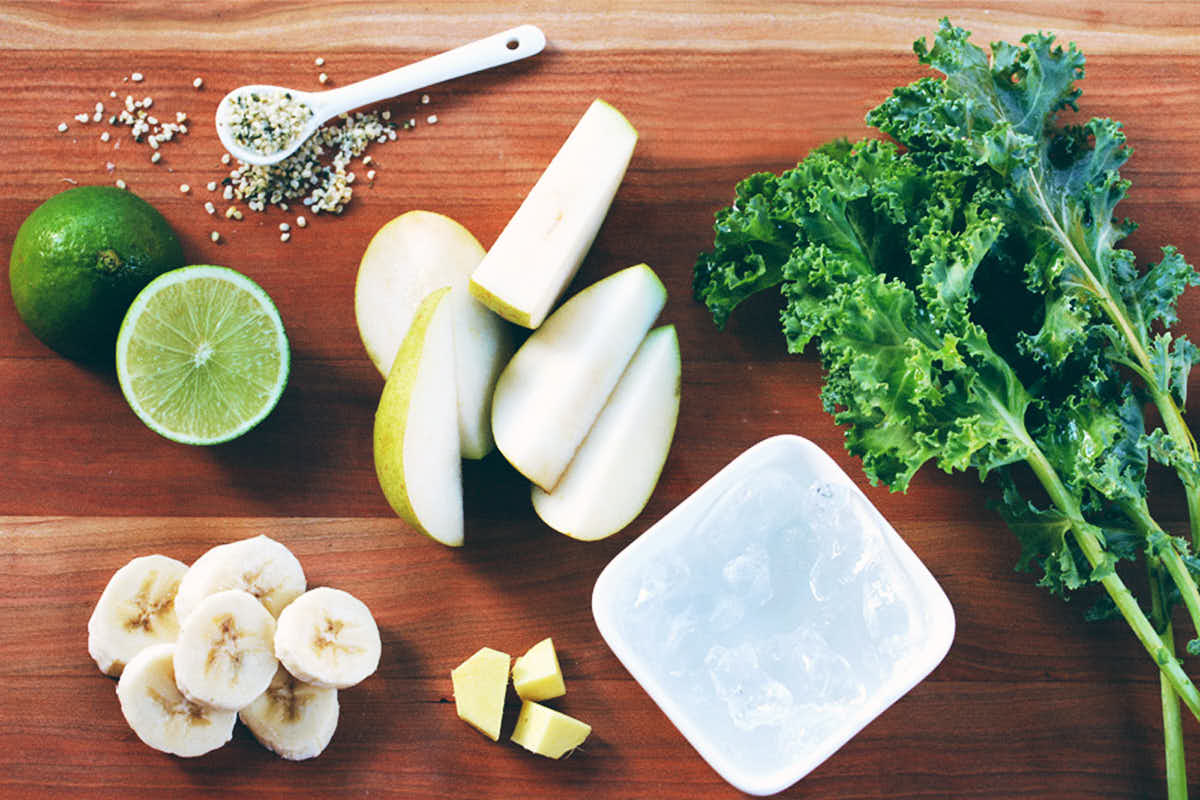Ingredients for green smoothie prepped on a cutting board