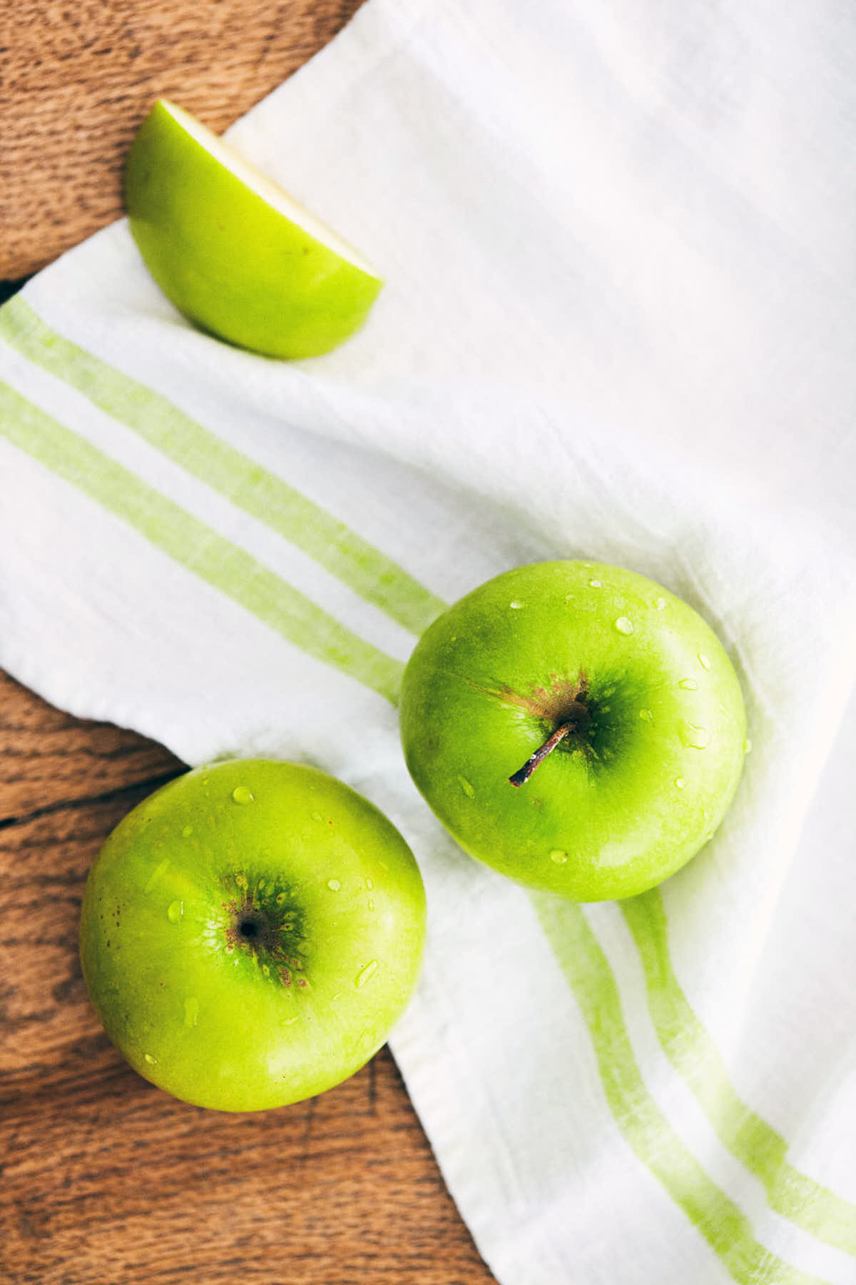 Washed green apples on a wooden table