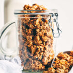 Nut pulp granola in a storage container with a scoop