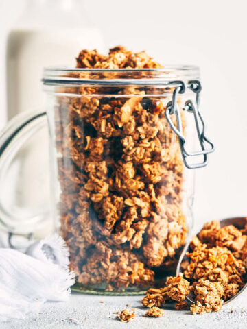 Nut pulp granola in a storage container with a scoop