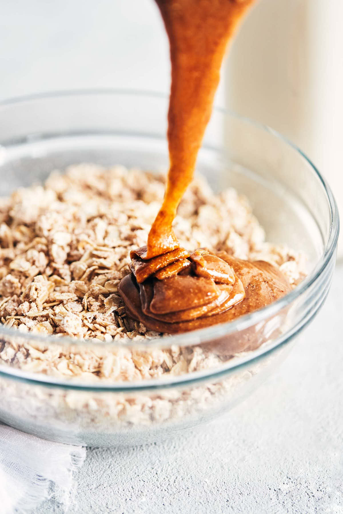 Almond butter being poured over oats