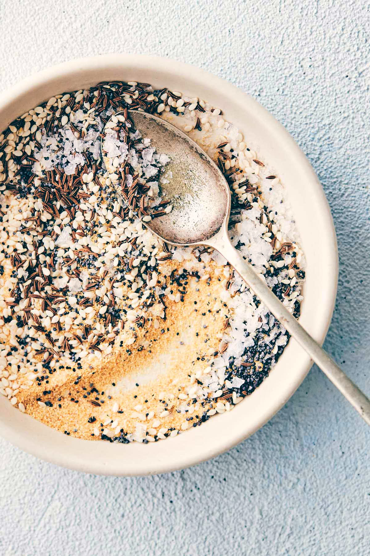 Everything bagel seasoning in a plate with a mixing spoon