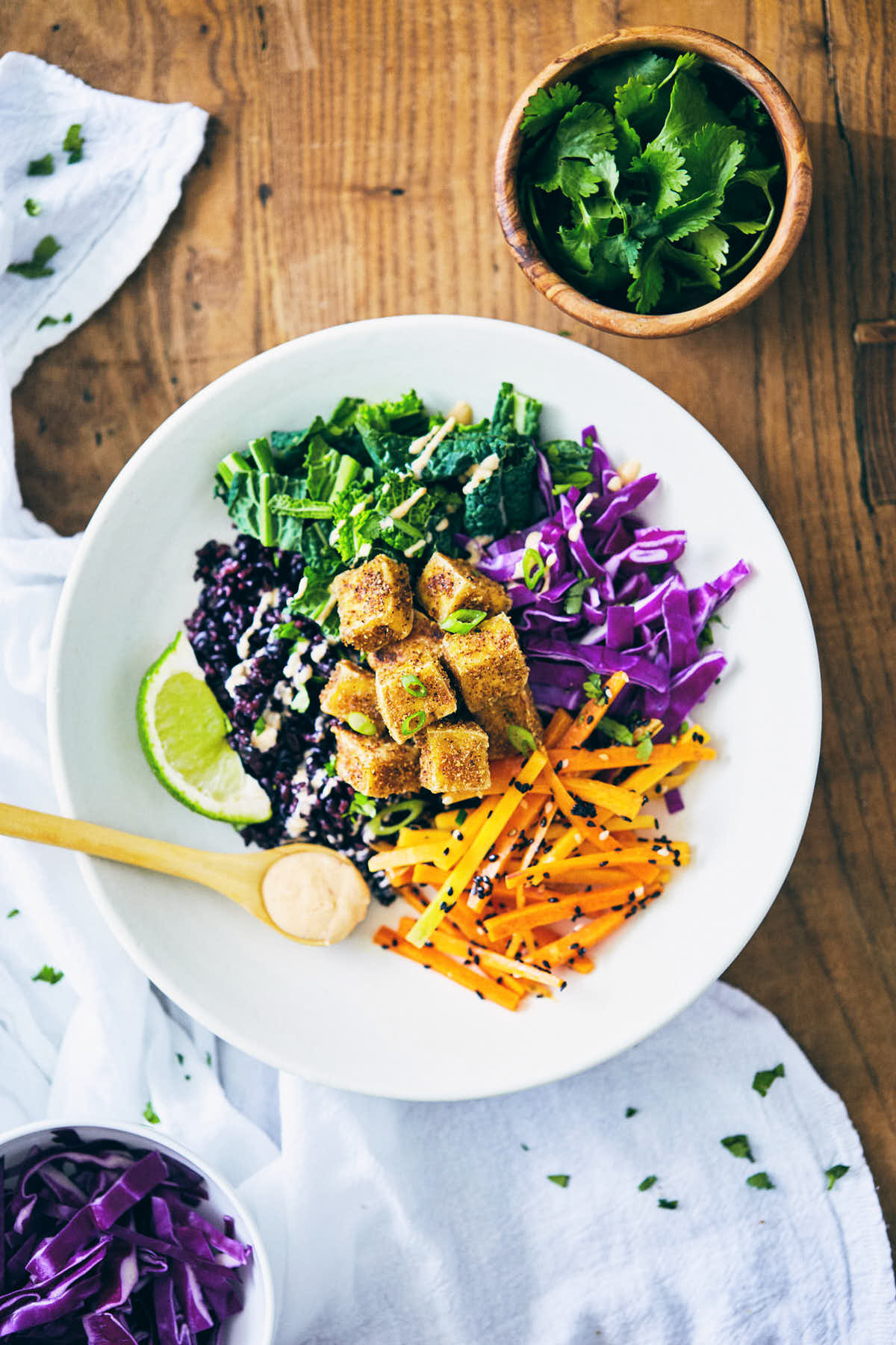 Forbidden rice buddha bowl with crispy tofu on a wooden table