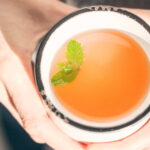 Holding grapefruit honey mint tea on a cold winter day