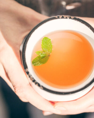 Holding grapefruit honey mint tea on a cold winter day