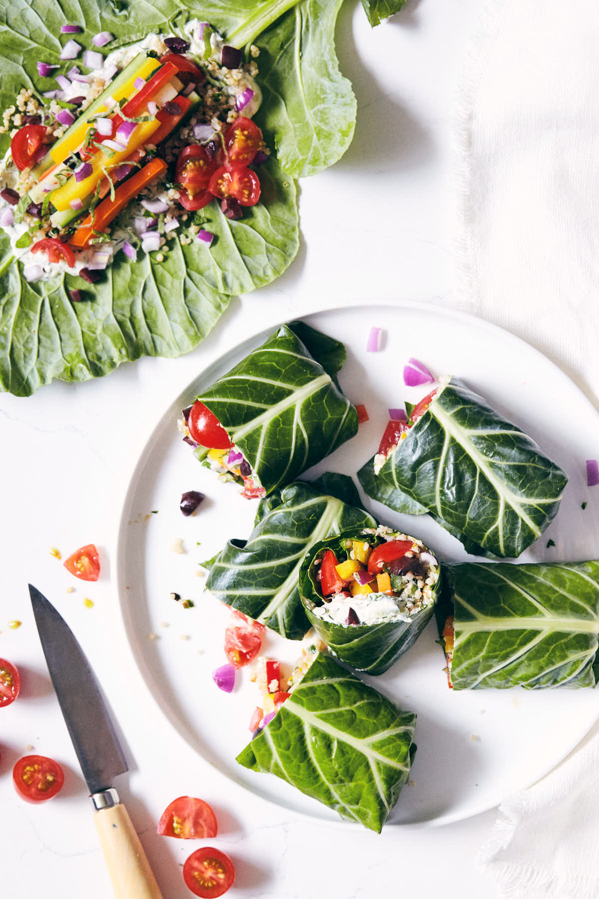 Plate of collard wraps cut in half with veggies inside visible