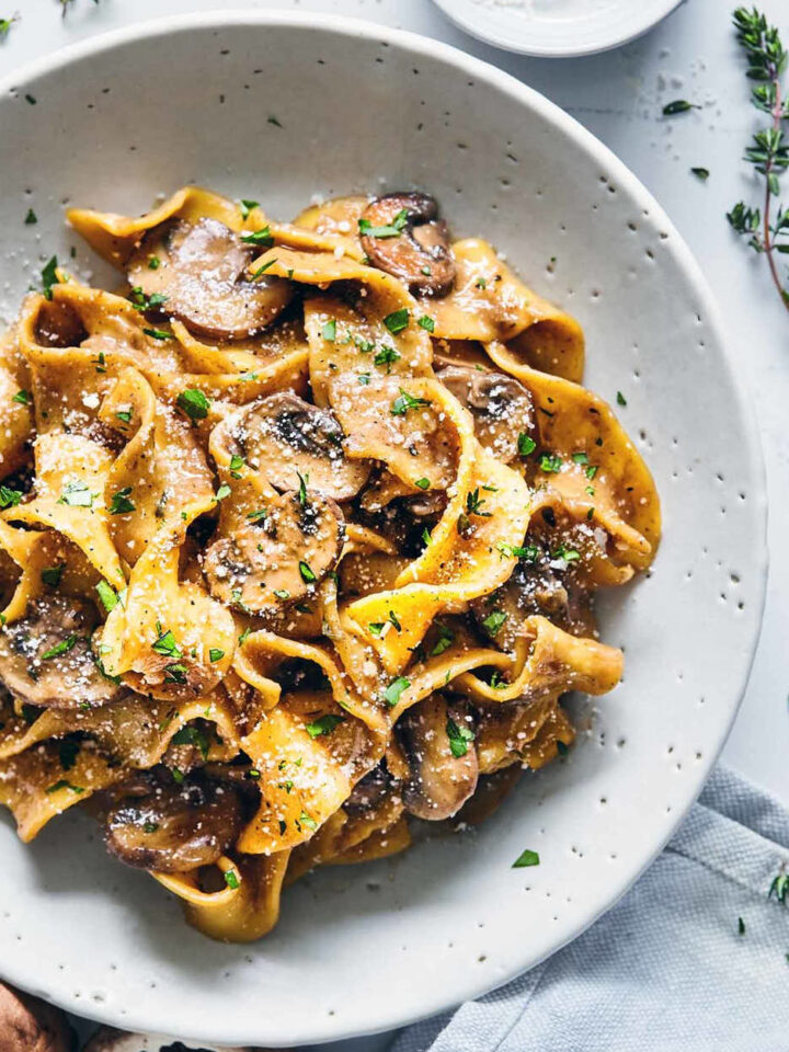 Mushroom stroganoff in a white plate with fresh thyme and parmasen