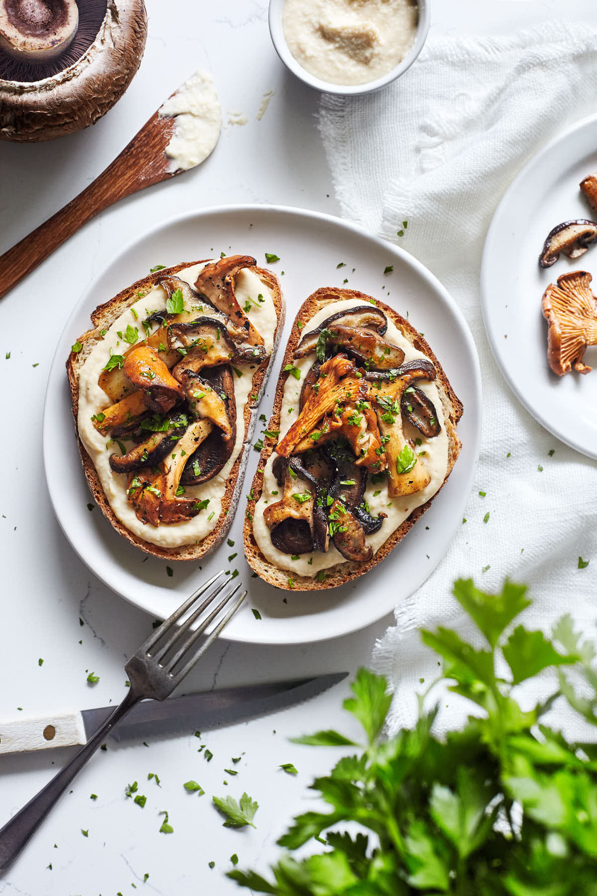 Plate of mushrooms of toast with white bean spread and topped with parsley