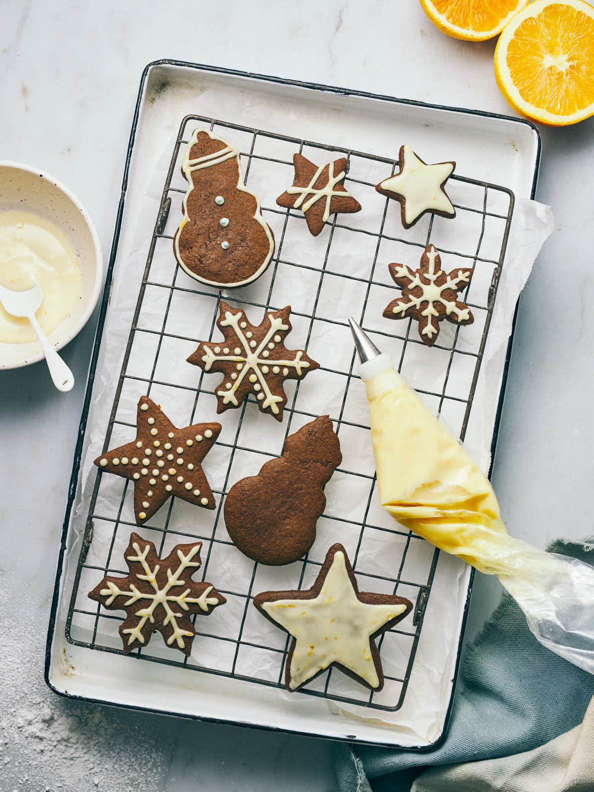 Gingerbread cookies on a cooling rack with orange icing piping bag