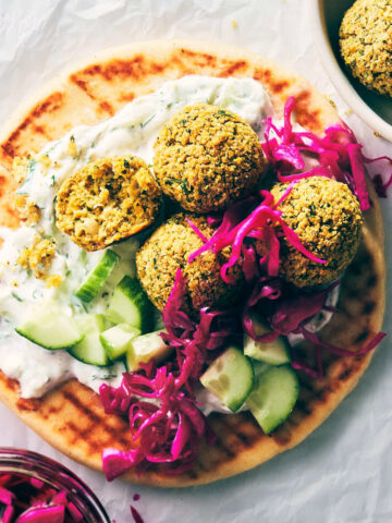 Close up of falafel on a pita with pickled cabbage and tzatziki