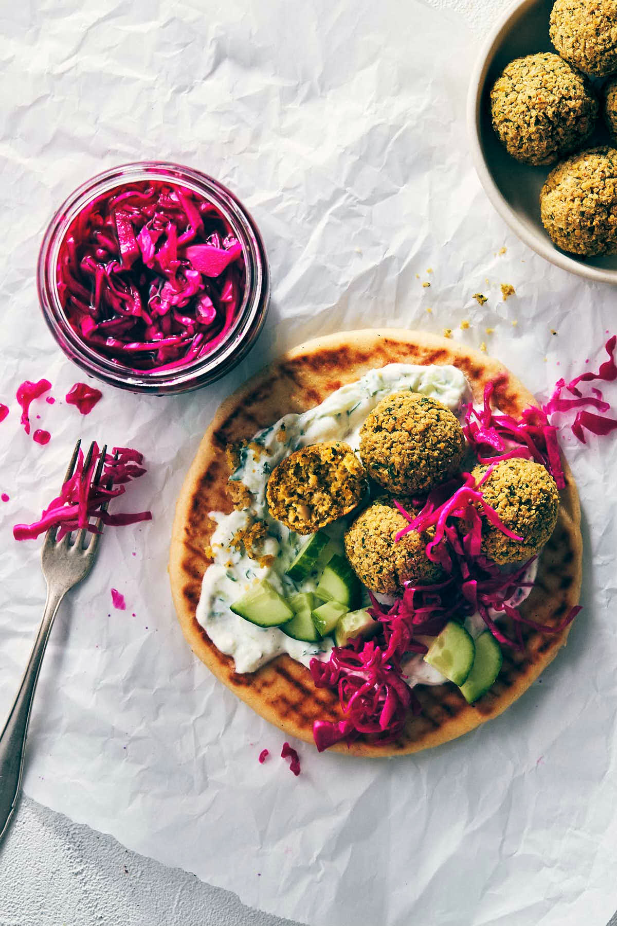 Oven baked falafel on a pita with tzatziki and pickled red onions