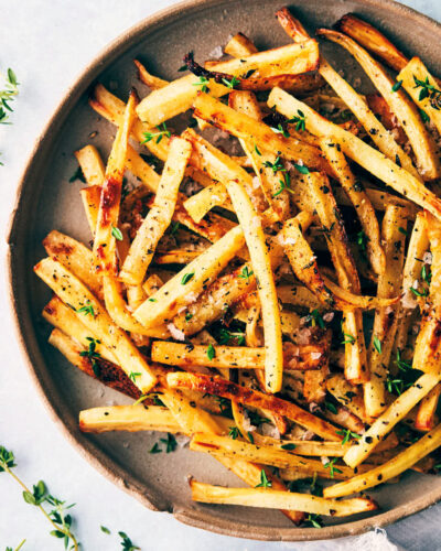 Plate of parsnip shoestring fries topped with thyme and flaky salt