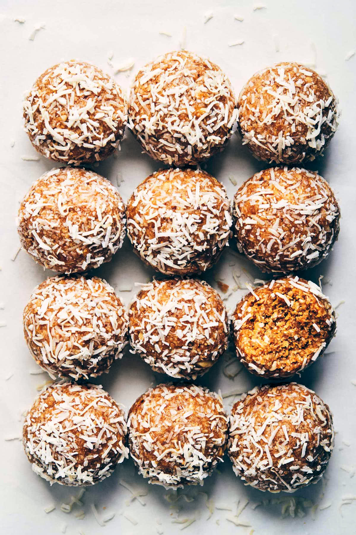 12 peanut butter coconut power balls on a marble background 