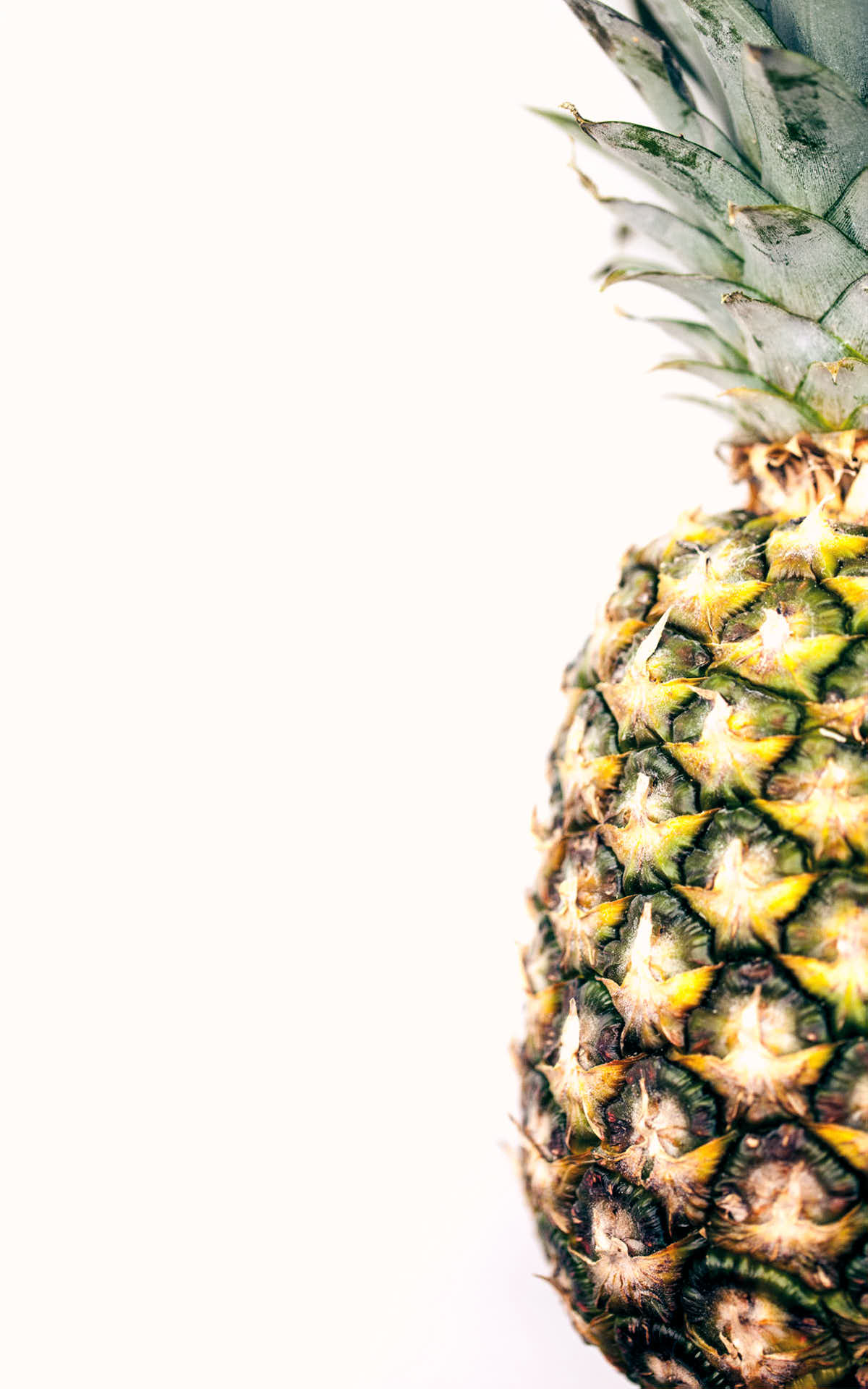 Uncut pineapple on a white background