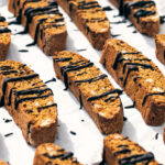 Side view of pumpkin pecan biscotti drizzled with melted chocolate
