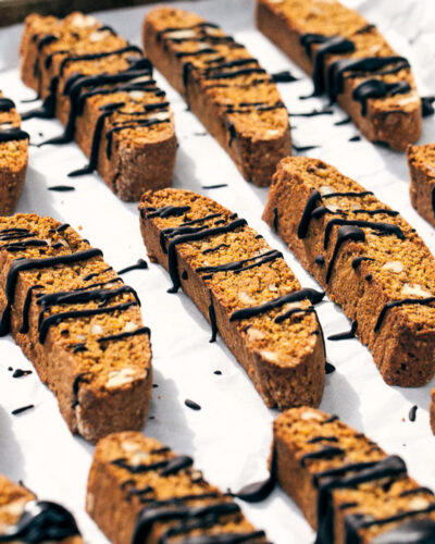 Side view of pumpkin pecan biscotti drizzled with melted chocolate