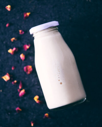 Rose honey almond milk on counter with rose petals