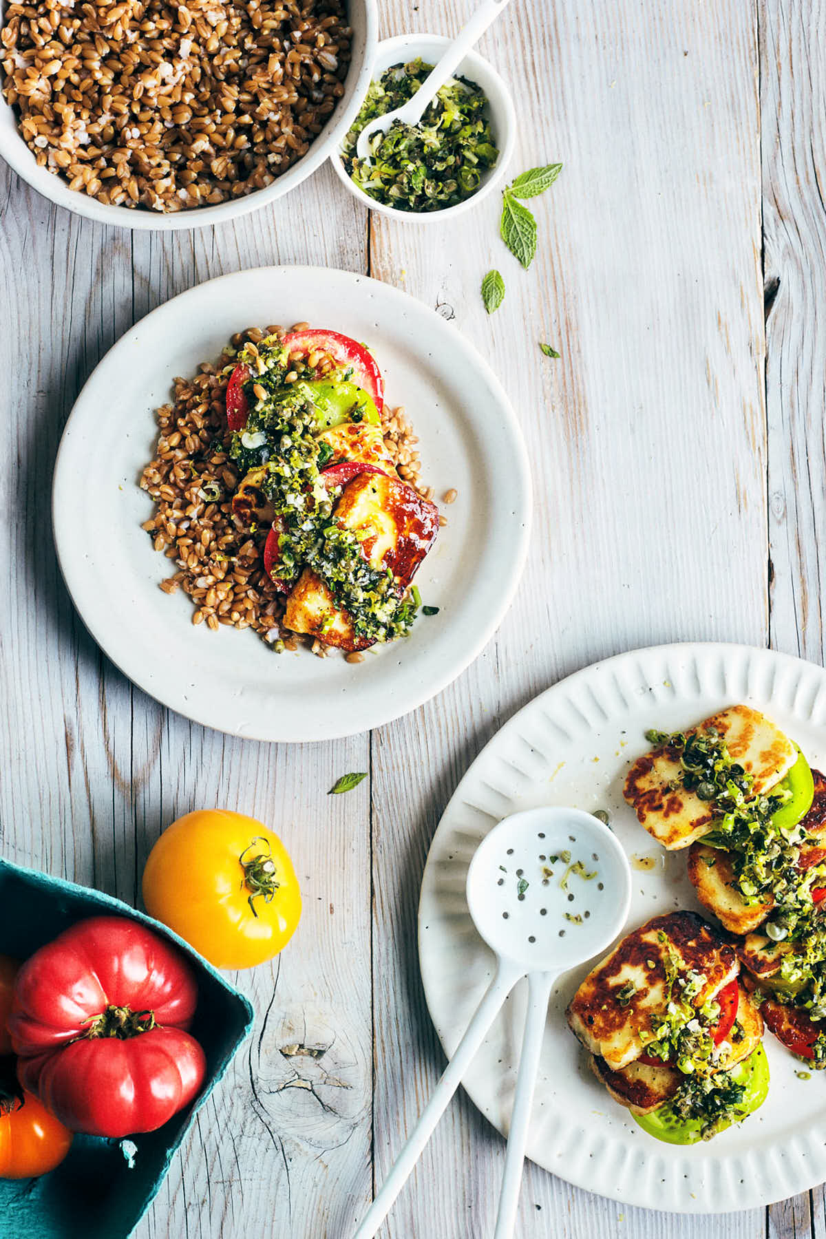 Seared halloumi served onto a plate with farro and topped with fresh herbs