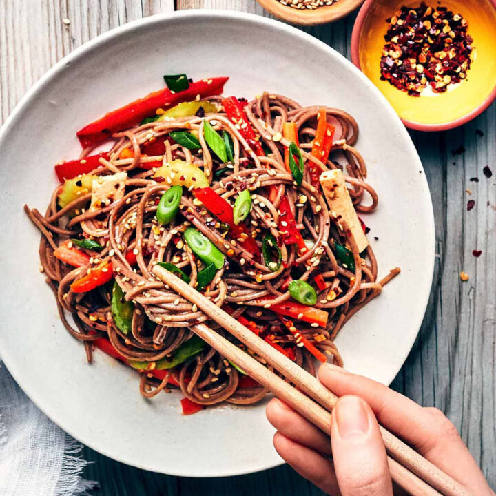 Digging into sesame soba noodle salad with chopsticks