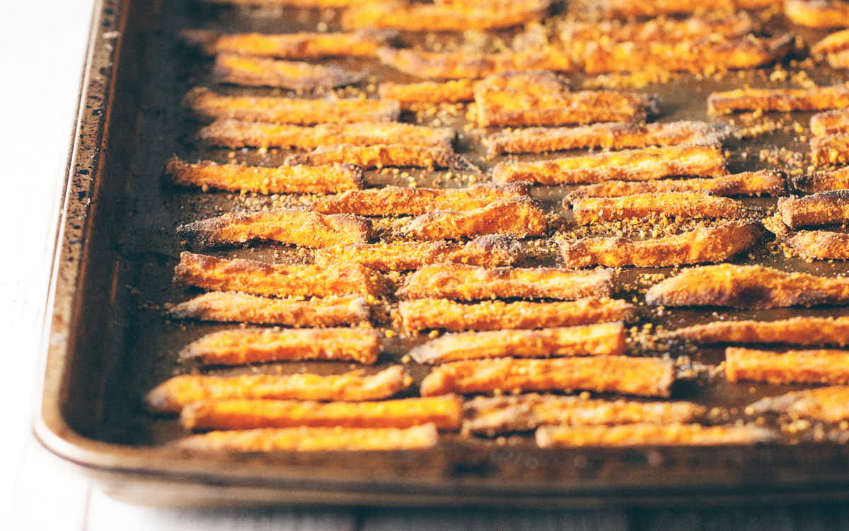 Spiced sweet potato fries arranged on a baking pan