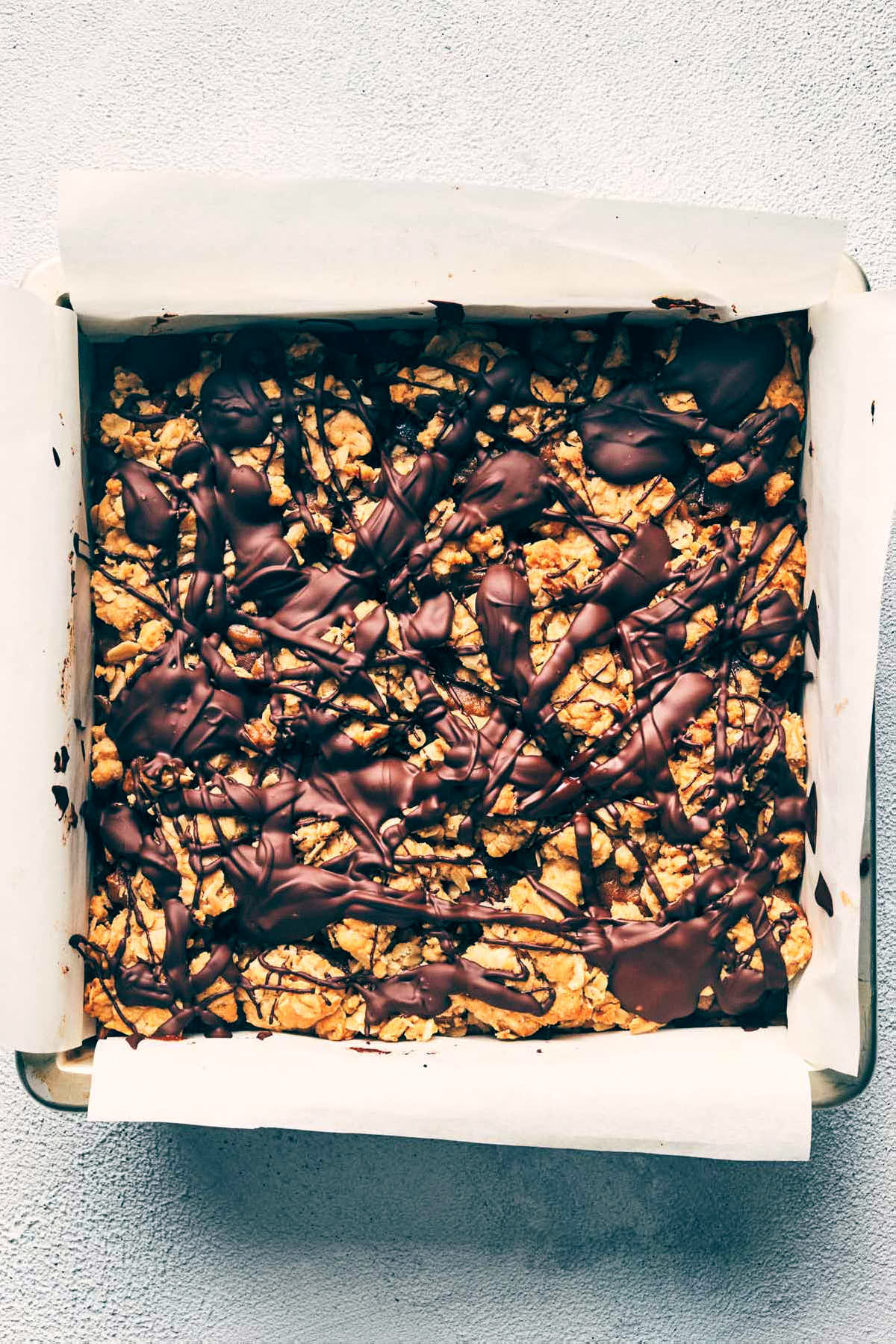 Caramelitas fully layered into baking pan with melted chocolate on top