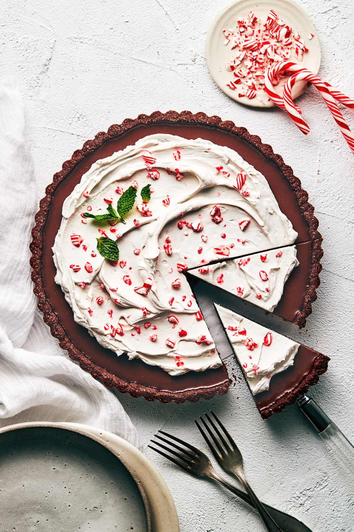 Chocolate peppermint tart topped with candy cake and sliced