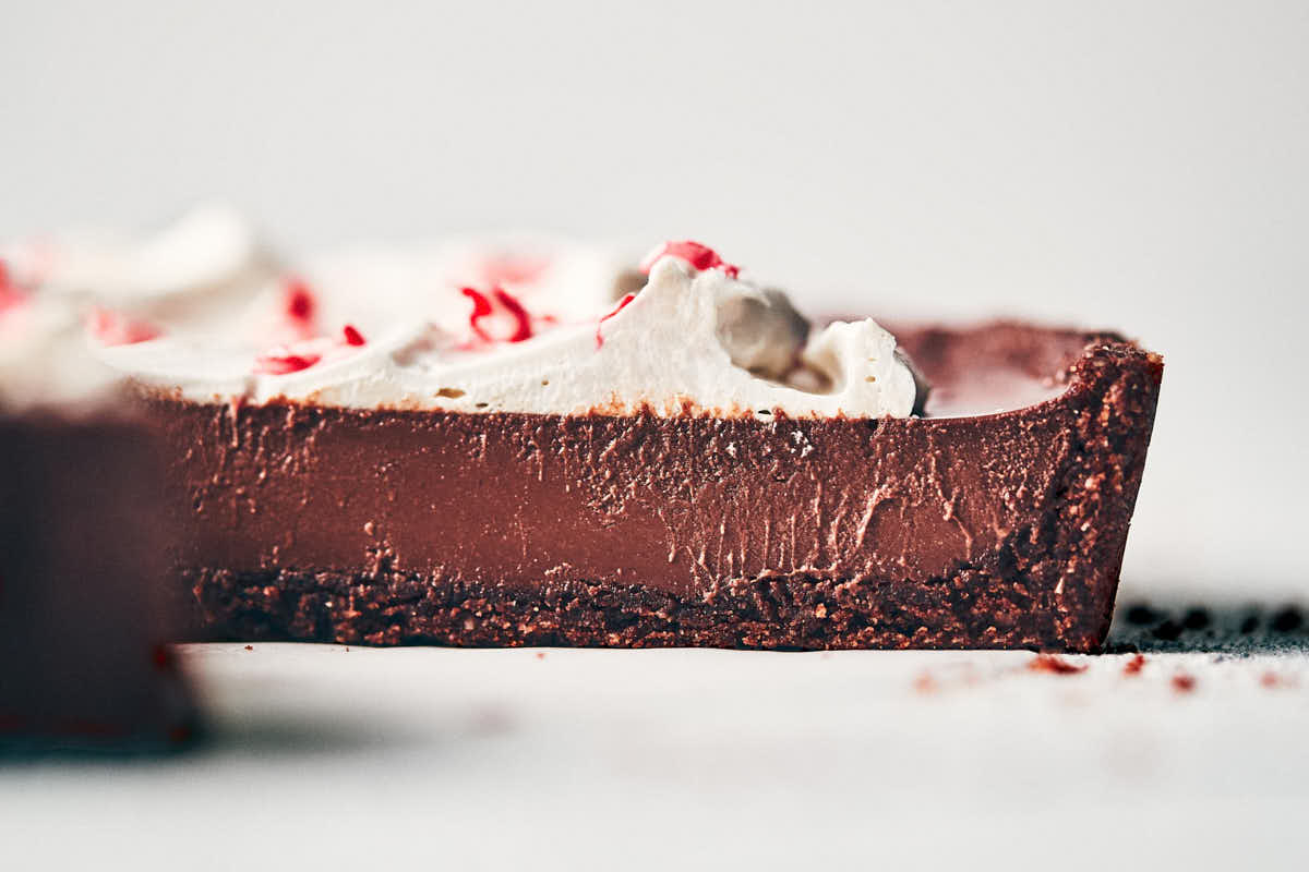 Side view of chocolate peppermint tart showing texture of filling and whipped cream topping