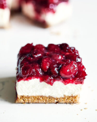 Side view of vegan cranberry cheesecake bar on a marble surface