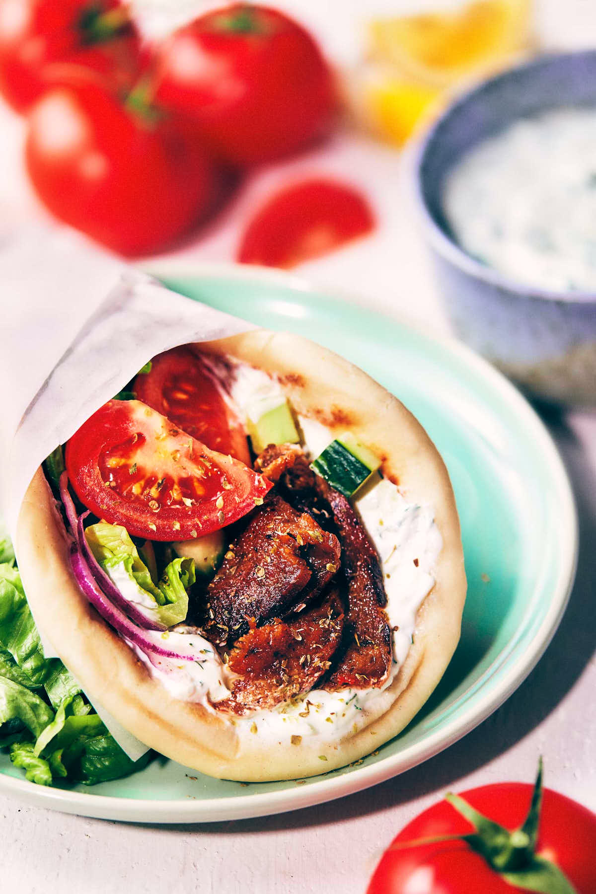 Close up of rolled up greek gyros on a light blue plate