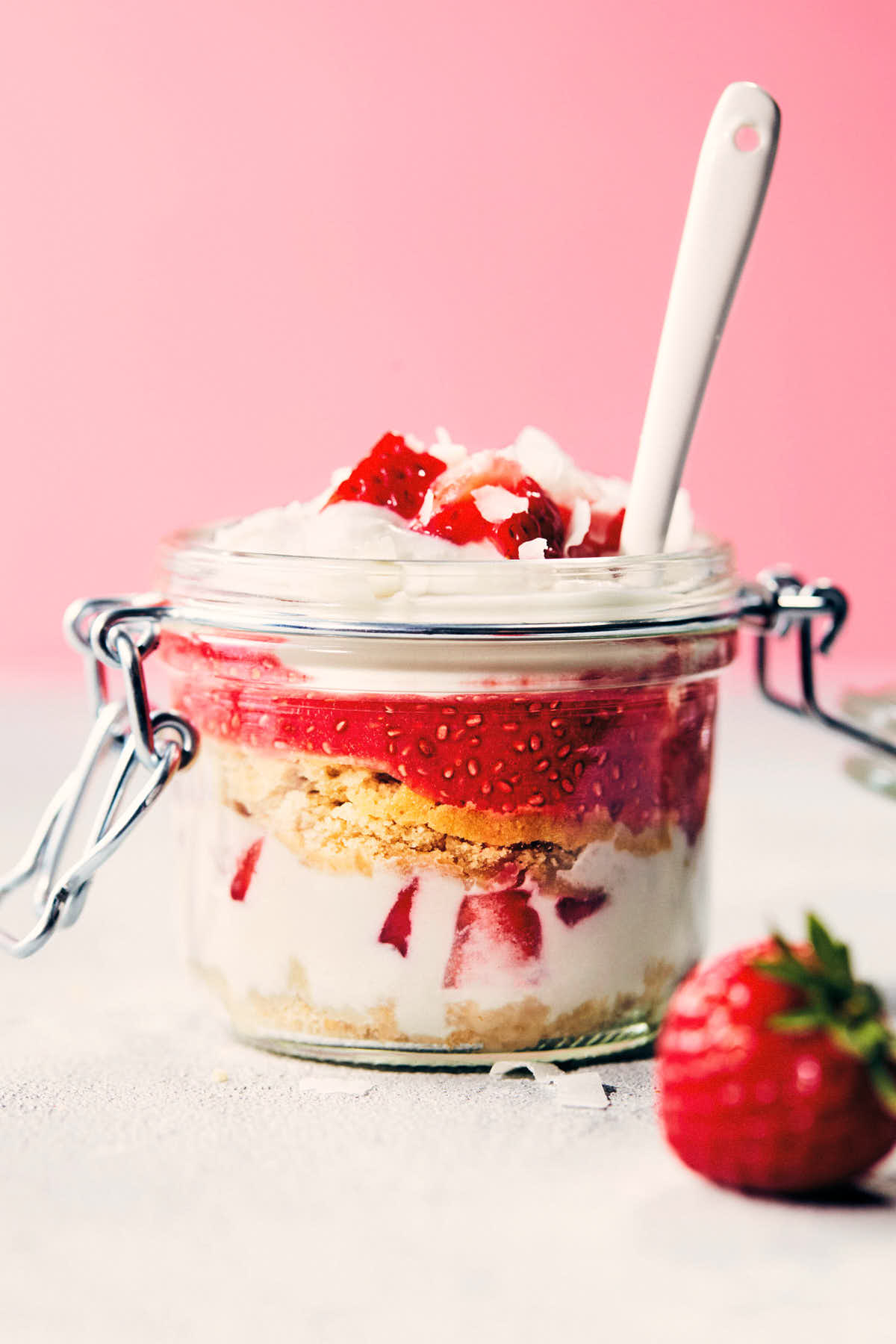 Strawberry shortcake trifle on a counter with a white spoon