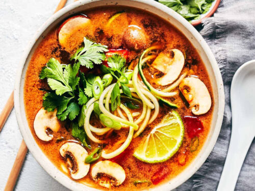 Bowl of vegan tom yum soup topped with fresh cilantro and lime
