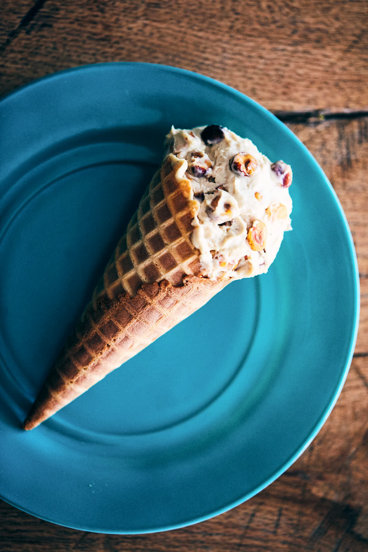 Whiskey hazelnut ice cream cone on a blue plate