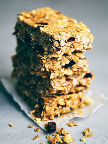 Stack of four chocolate macadamia nut granola bars on a grey counter