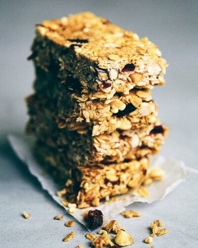 Stack of four chocolate macadamia nut granola bars on a grey counter