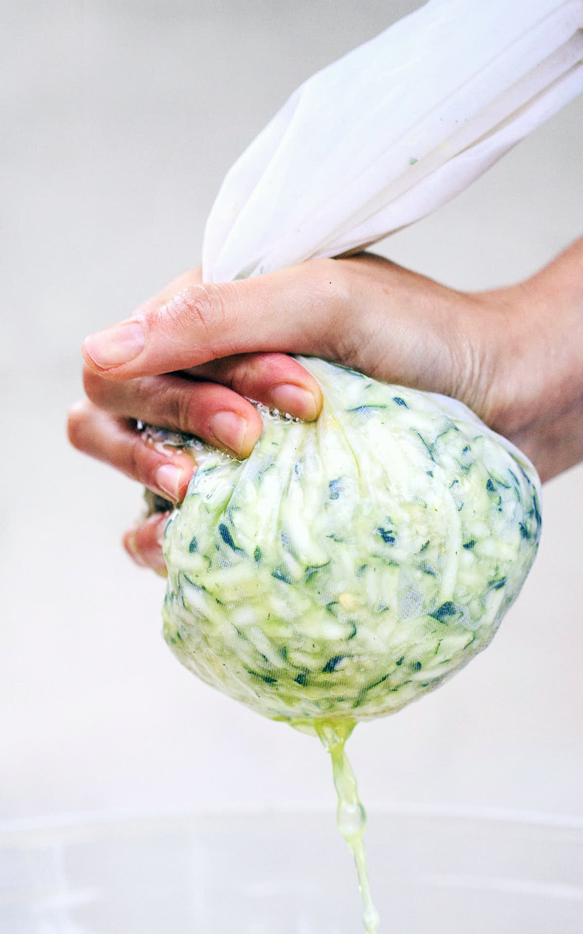 Squeezing excess water from zucchini with milk cloth bag