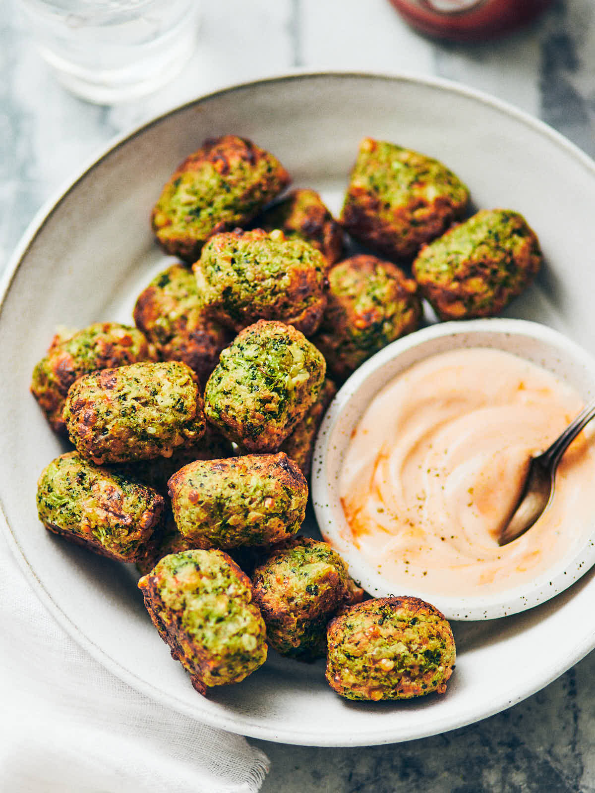 A bowl of air fryer broccoli tater tots with creamy buffalo dip
