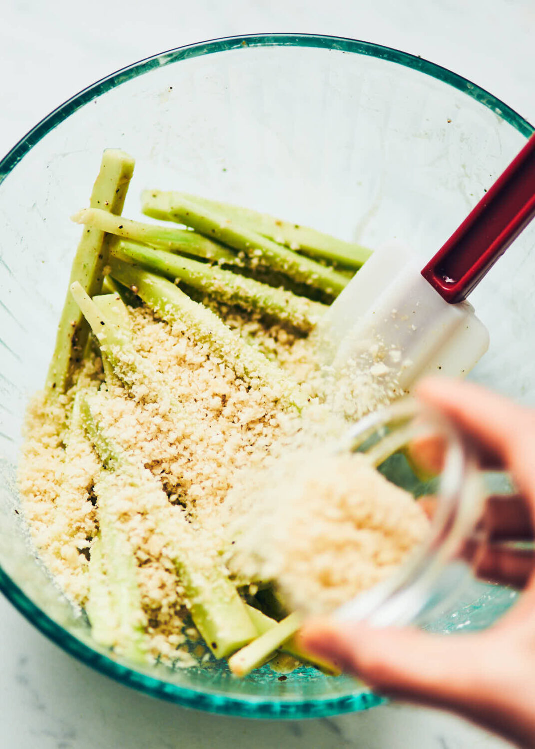 Coating cut broccoli stalks with panko breadcrumb mixture