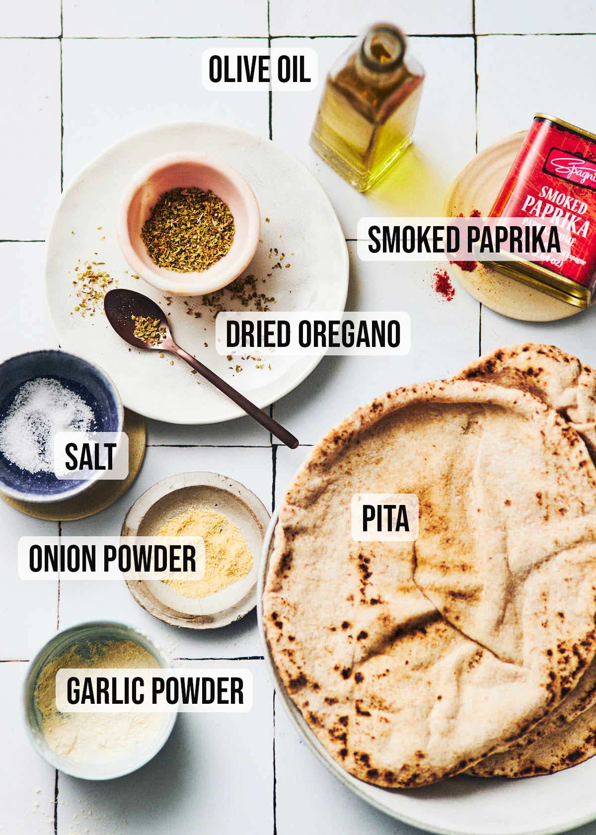 Ingredients to make air fryer pita chips: olive oil, smoked paprika, dried oregano, salt, pita, onion powder, garlic powder.
