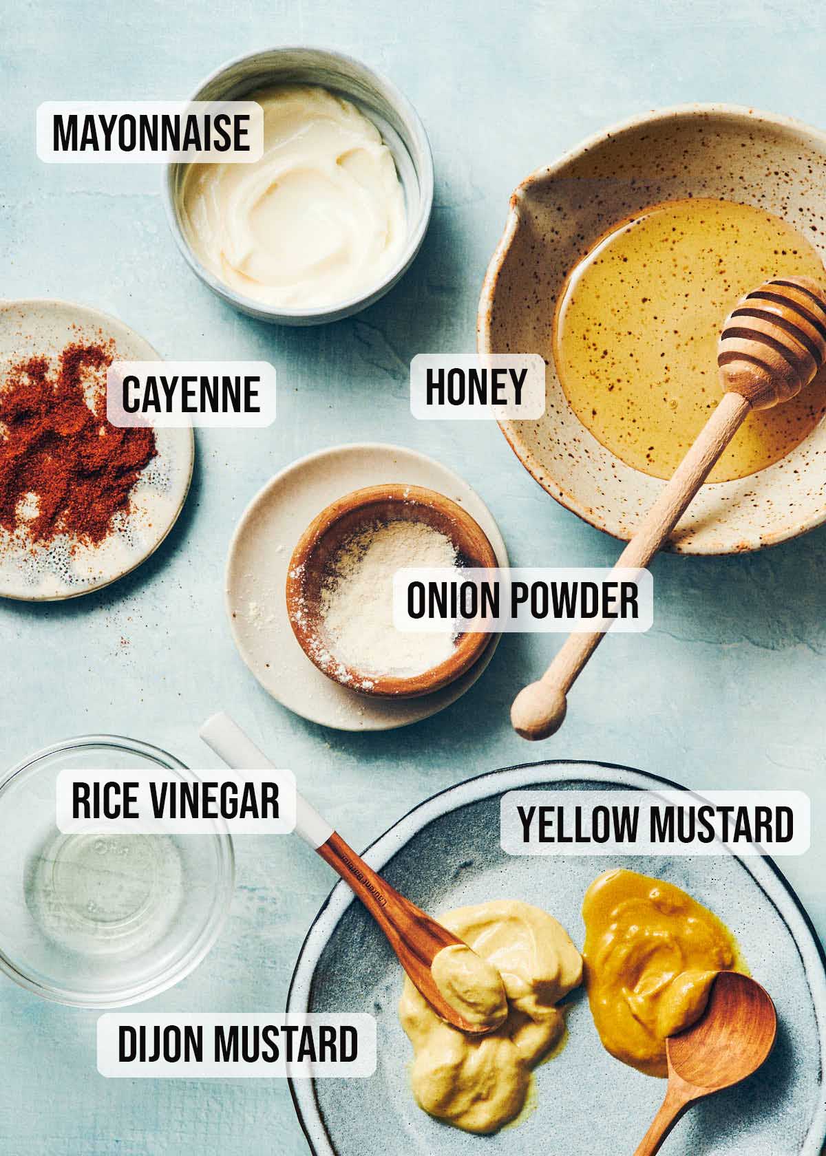 Ingredients to make homemade honey mustard sauce: mayonnaise, honey, onion powder, yellow mustard, dijon mustard, rice vinegar, and cayenne