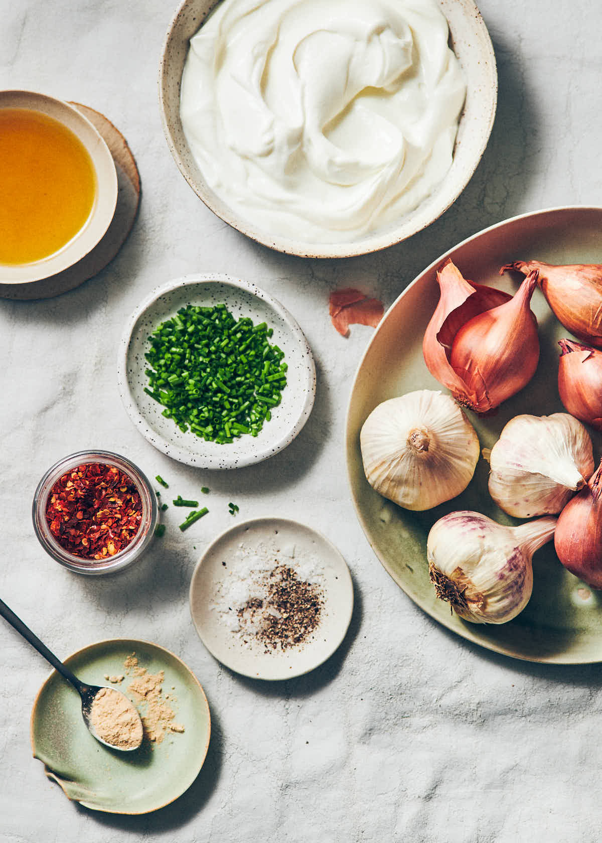 Ingredients to make Greek Yogurt onion dip: yogurt, fresh chives, chili flakes, olive oil, garlic, shallot, and garlic powder.