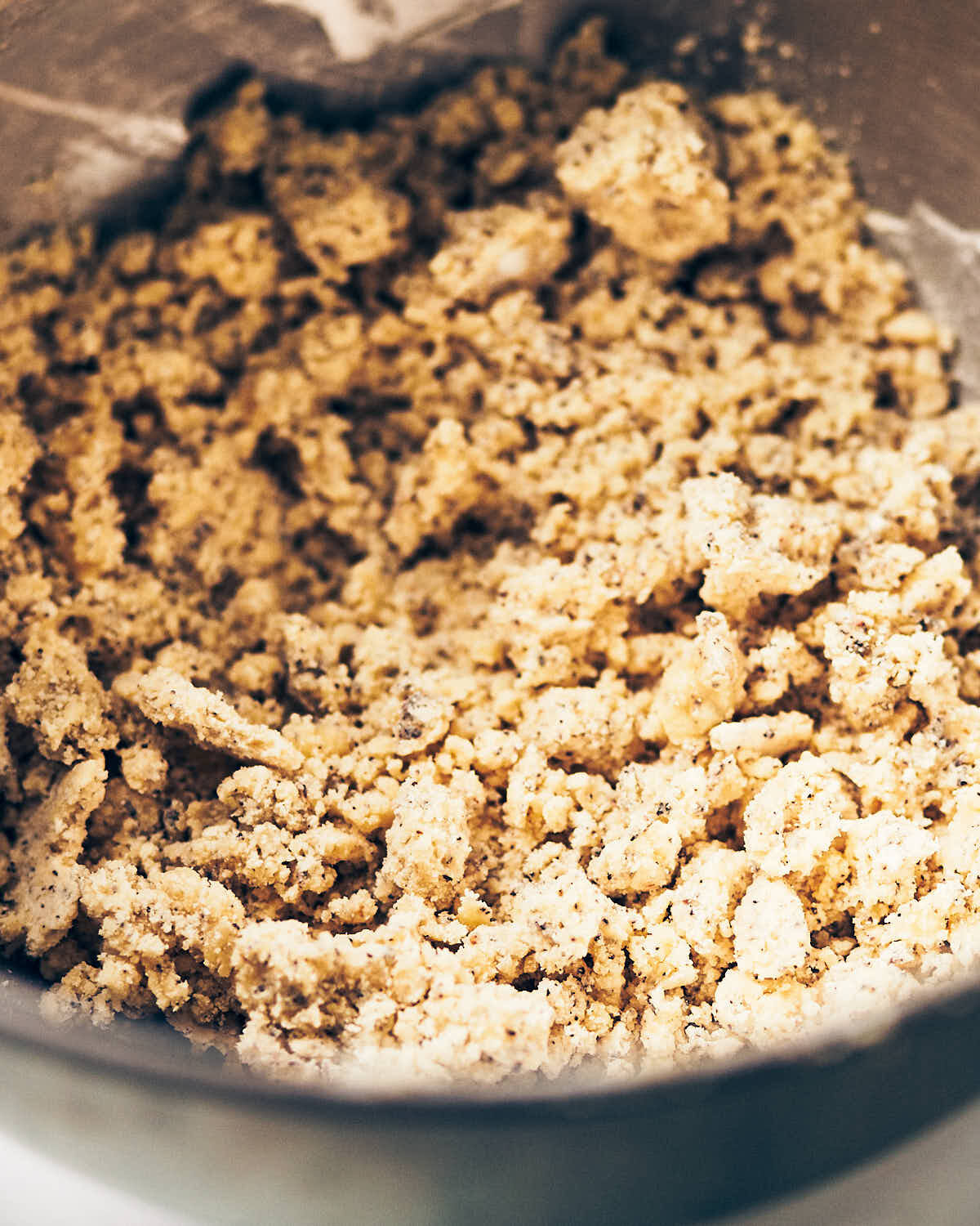 Crumbly dough for earl grey shortbread cookies in a mixing bowl.