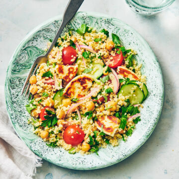 Halloumi Couscous Salad with Lemon on a green plate with a fork.