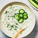 A bowl of creamy Jalapeno Ranch Dip with Greek Yogurt topped with sliced jalapenos.