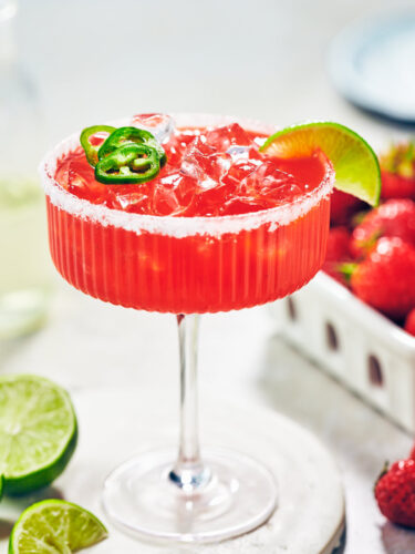 Easy Strawberry Jalapeno Margarita in a glass with fresh lime.