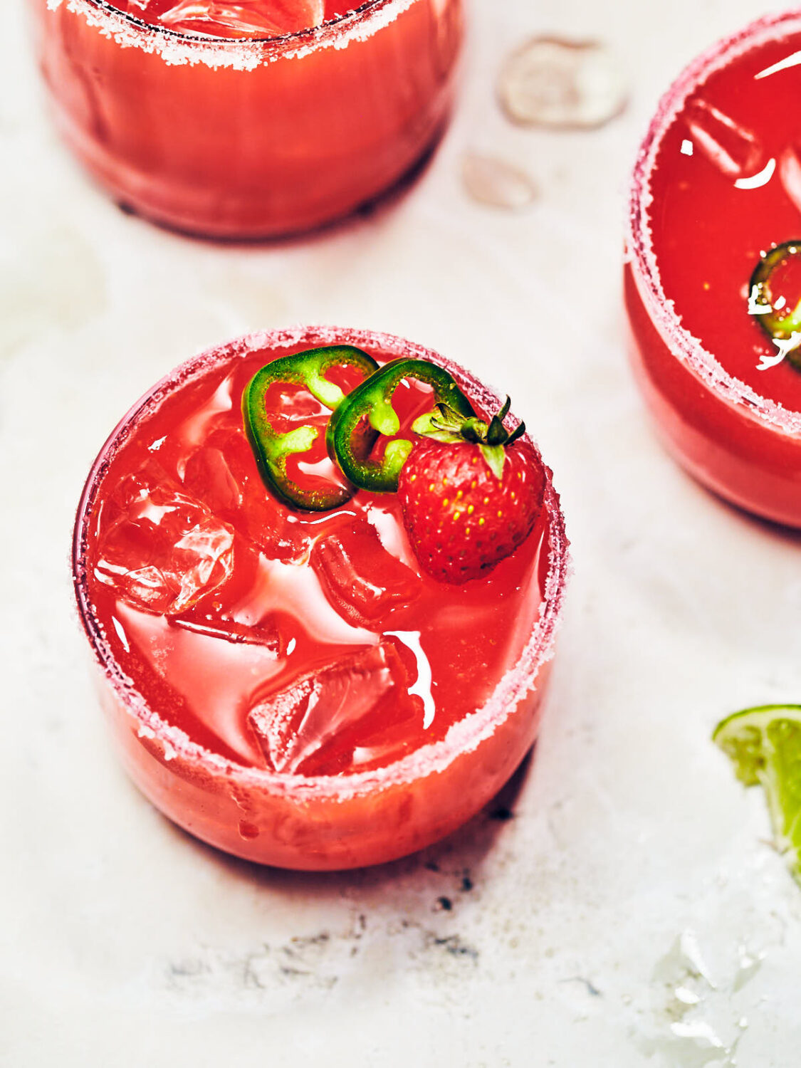 Easy Strawberry Jalapeno Margarita in a glass rimmed with salt and sugar.